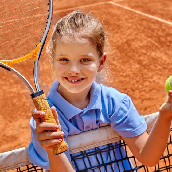 Jeune fille tenant une raquette de tennis