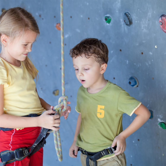 Enfants qui vérifient leurs harnais d'escalade